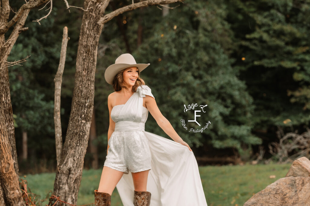 western bride in a sparkle romper holding train laughing