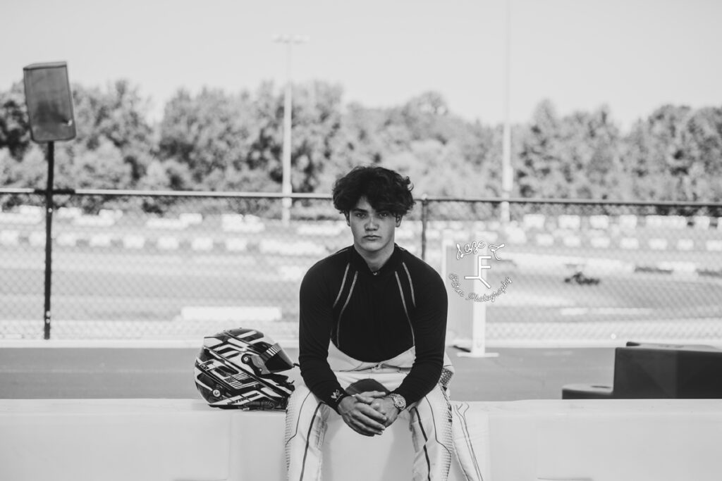 tyler sitting in front of track in black and white