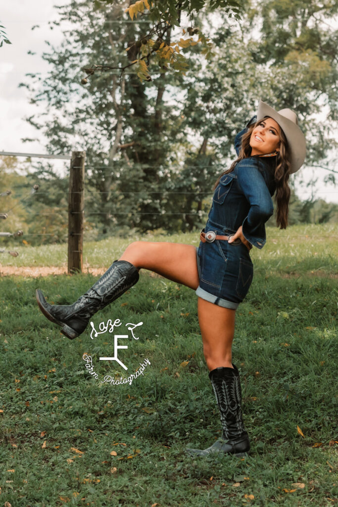 model in blue jean romper with cowboy hat and black boots