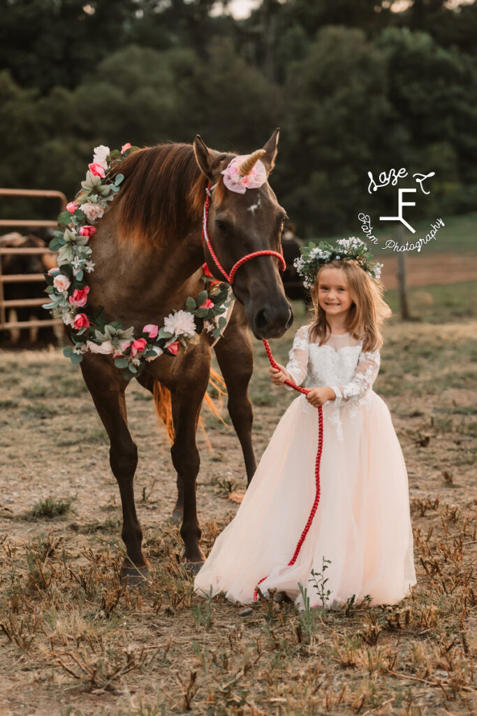 little sister with her unicorn dressed horse