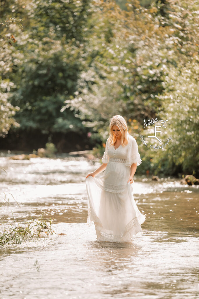 model standing in creek in white dress