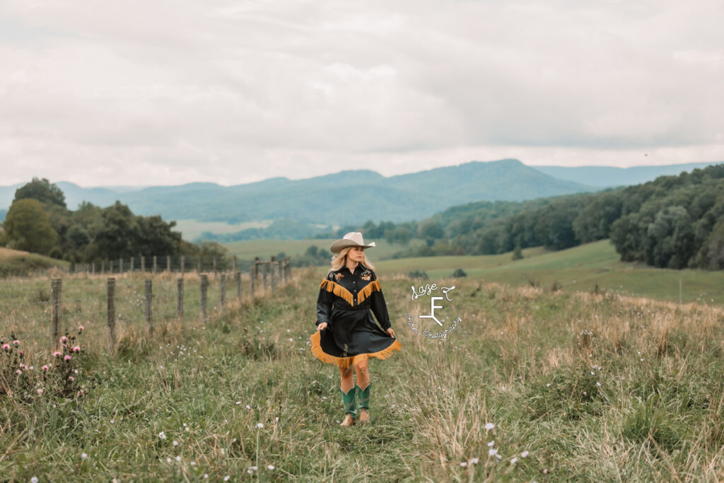 cowgirl in vintage blue dress with gold fringe in a field