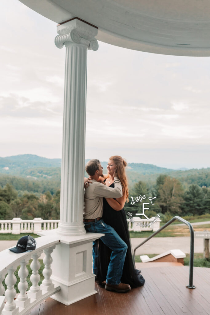 couple leaned against a column with mountain in the back