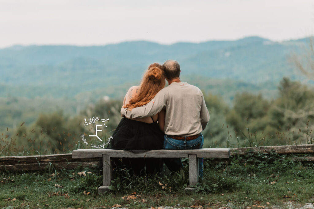 couple sitting on a bench looking at the mountains