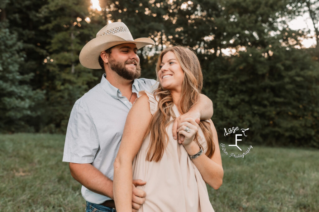 cowboy and wife standing in a field facing the same way