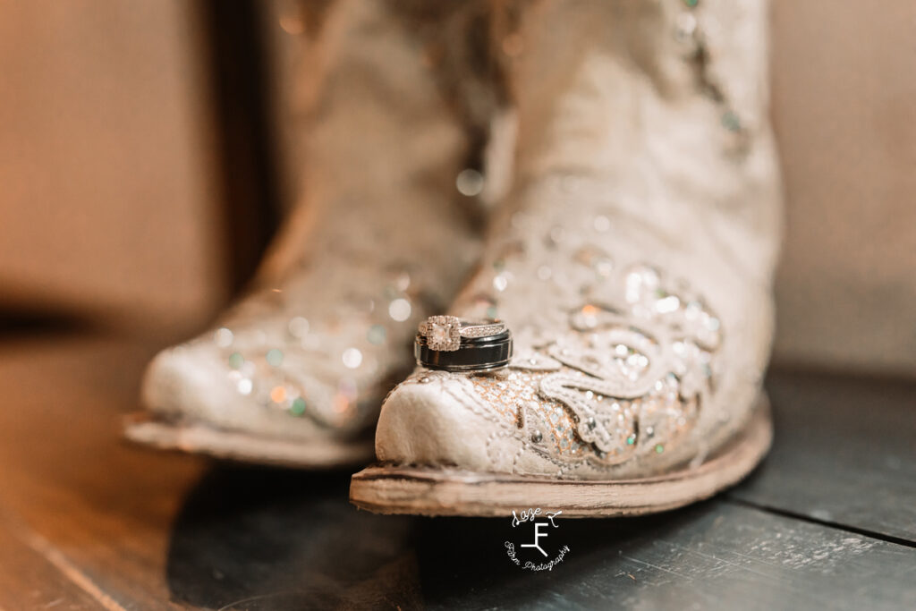 bride and groom rings on brides cowgirl boot