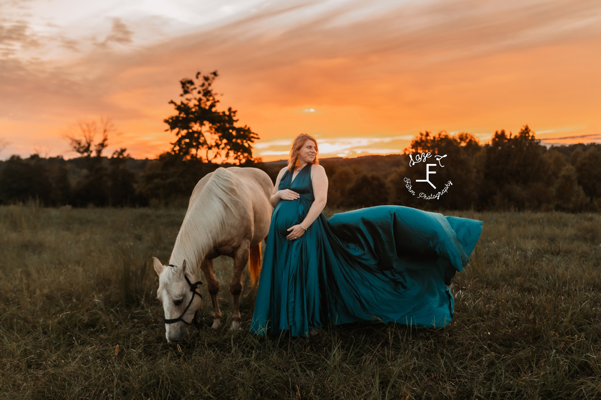 pregnant cowgirl with her horse at sunset in teal dress