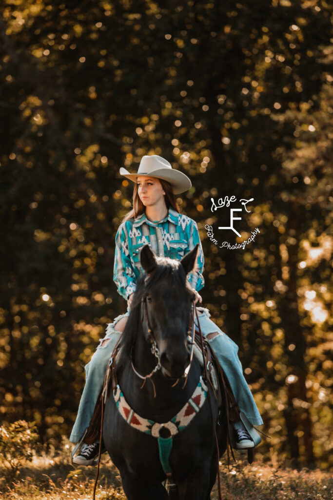 brunette cowgirl riding black horse