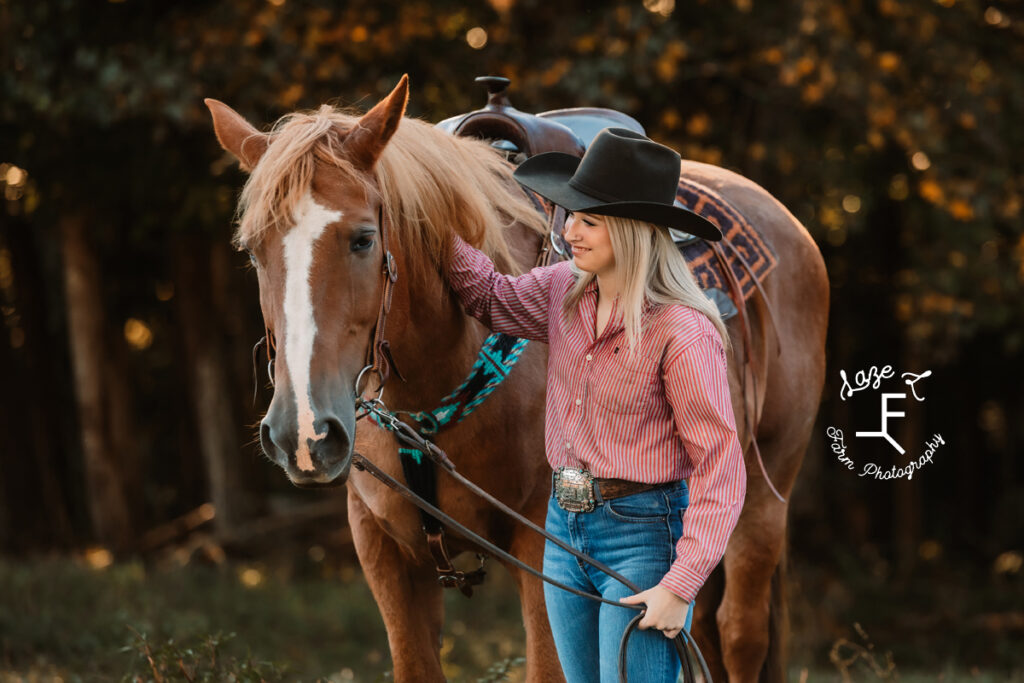 blond cowgirl with Belgium cross standing