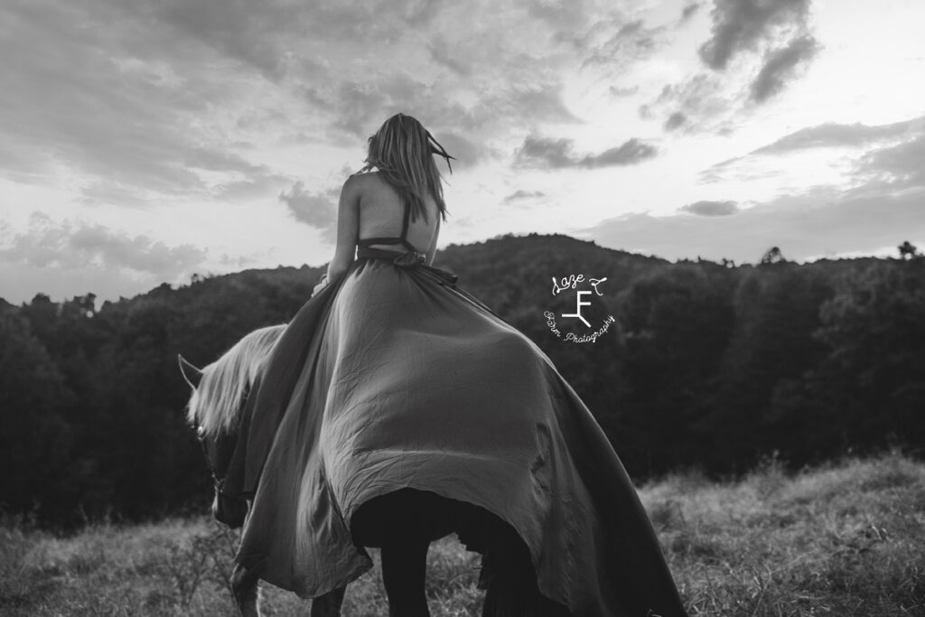 model riding away with mountain in back ground in black and white