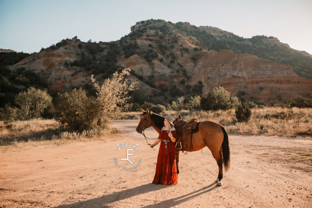 blond cowgirl with horse in canyon