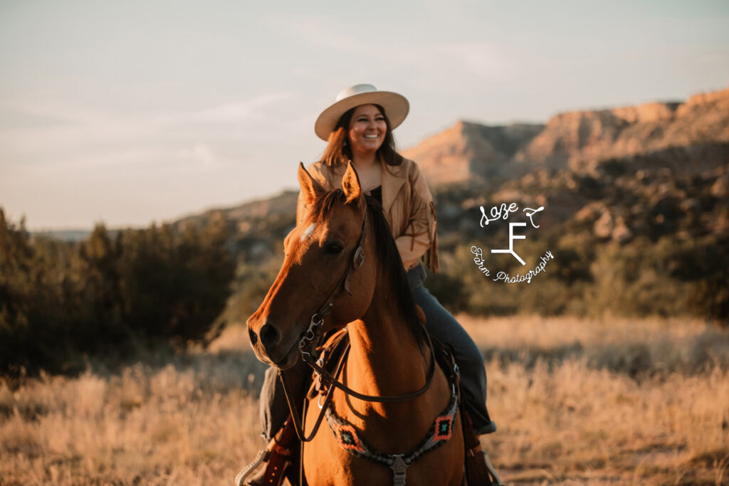 brunette cowgirl riding horse with canyon in background