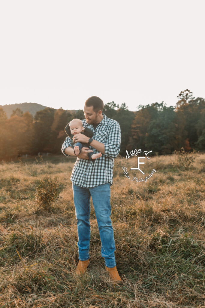 dad holding baby and looking at him