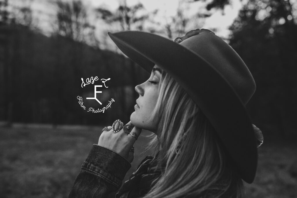 Cowgirl holding face toward the sun in black and white