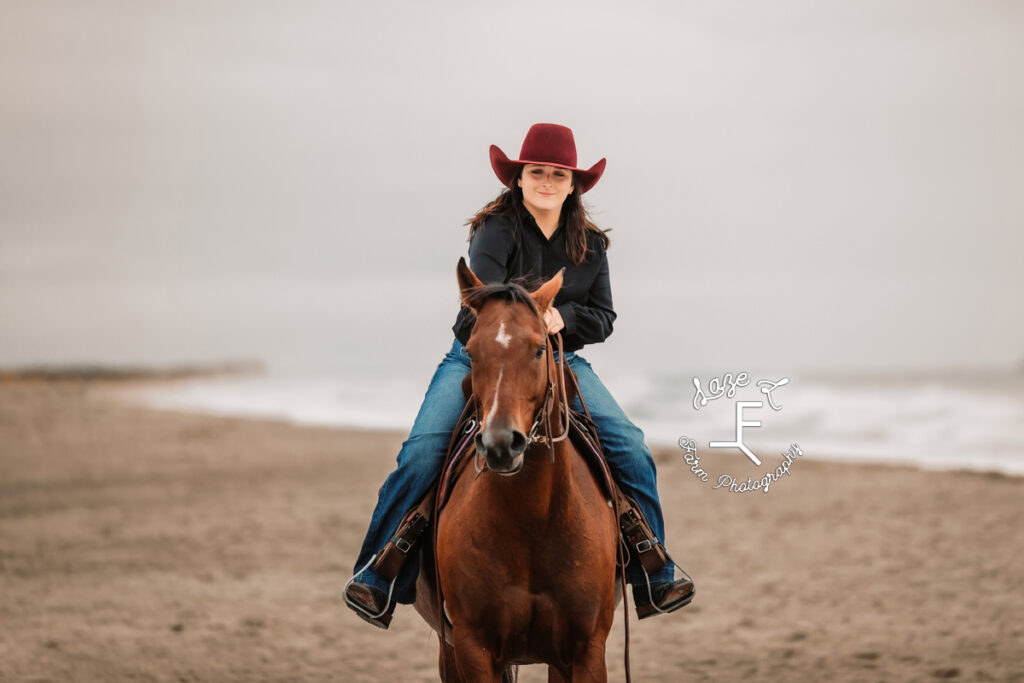 cowgirl petting horse while riding toward camera