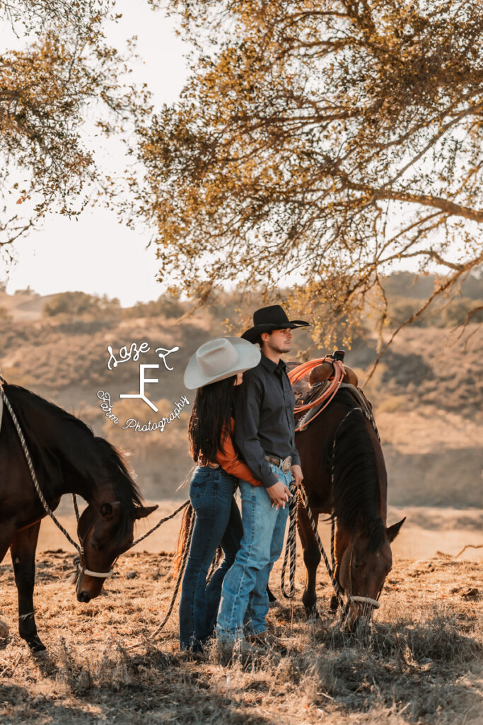 western couple embracing with their horses standing with them