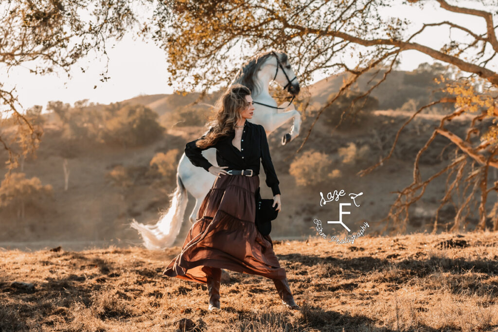 cowgirl with Andalusian rearing in the background