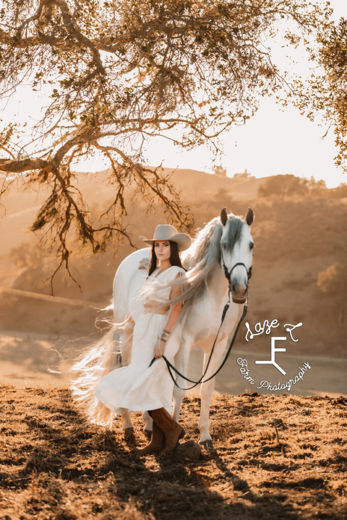 Cowgirl in white dress with Andalusian