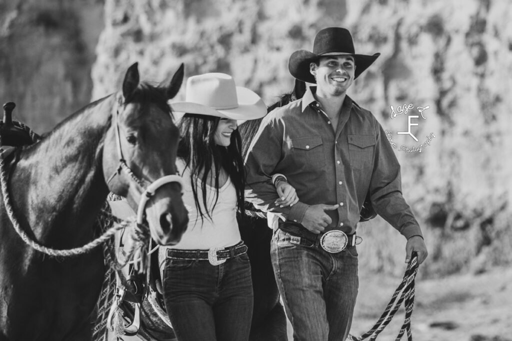 couple walking with their horses in black and white