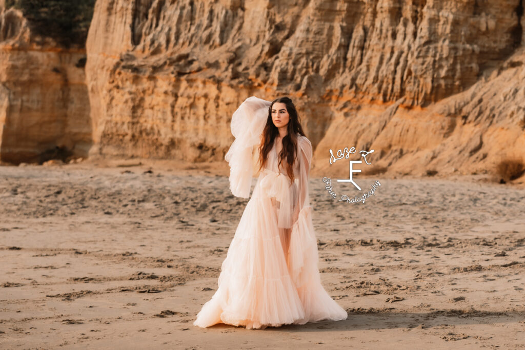 model in light pink robe dress on beach