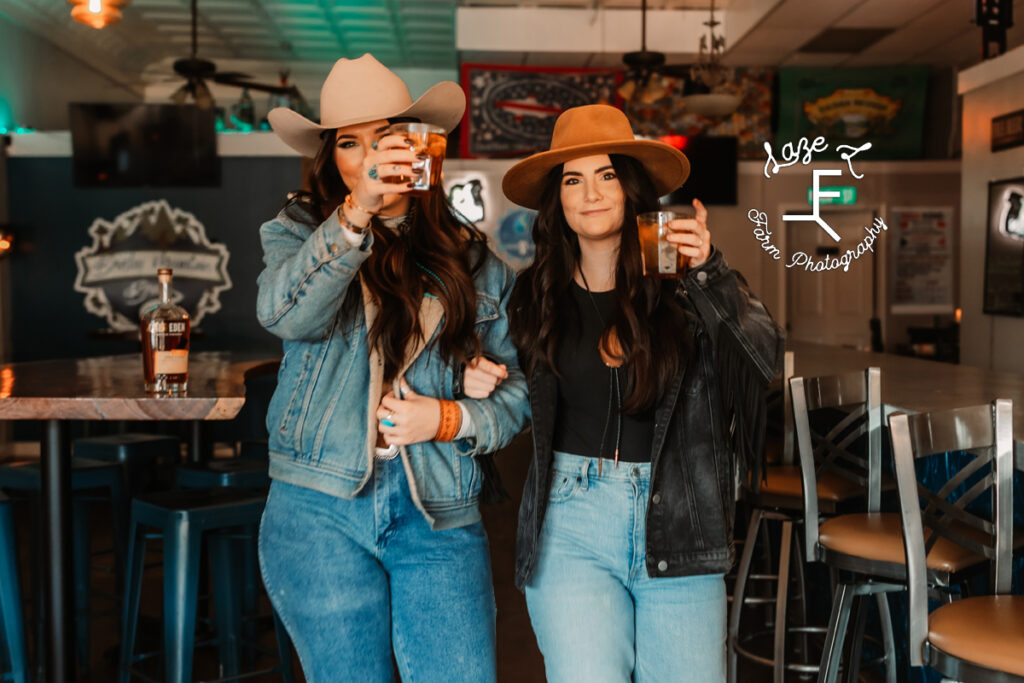 cowgirls walking out of bar raising glasses