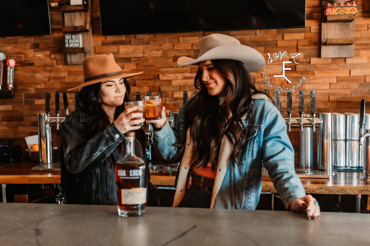 2 cowgirls doing a cheers with glasses