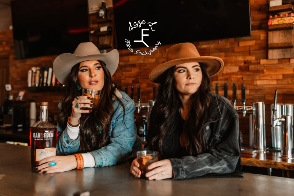 2 cowgirls sitting at bar looking out the window