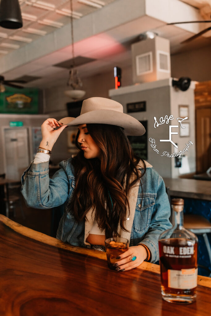 cowgirl standing at barn looking left