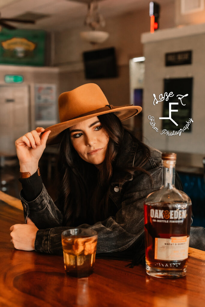 cowgirl standing at bar looking right