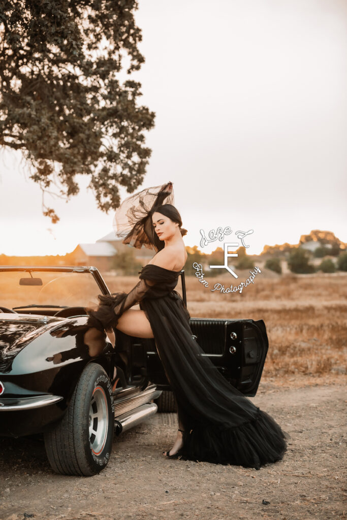 model standing with foot in door of corvette with dress flowing