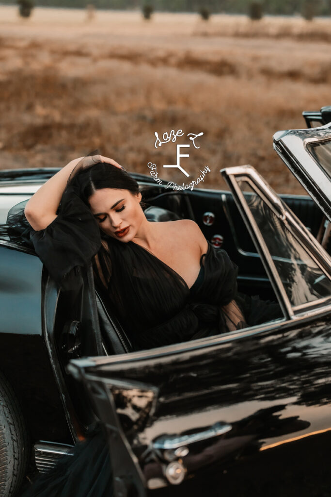 model sitting in corvette with arm on the side