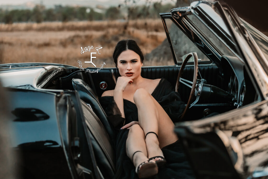 model sitting in corvette with legs stretched across center console