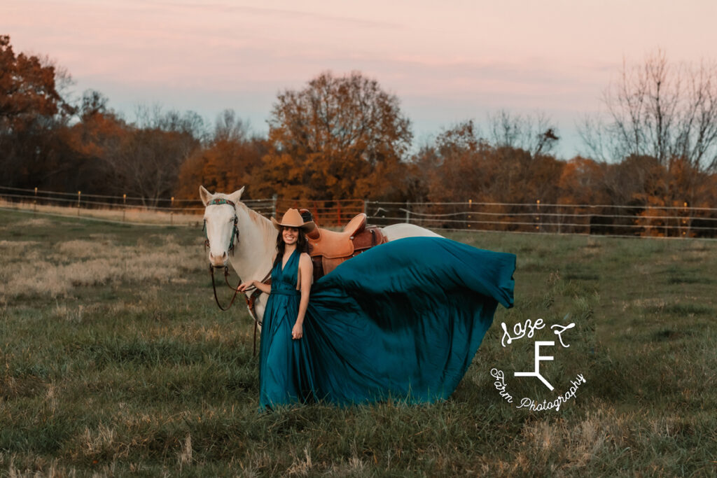 cowgirl in aqua dress with white horse