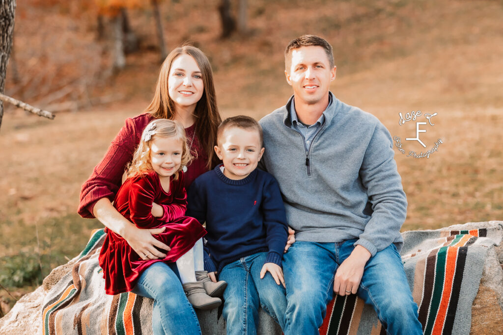 Family of 4 with little kids sitting on rock