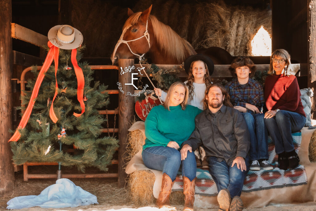 family sitting with Gus in the barn