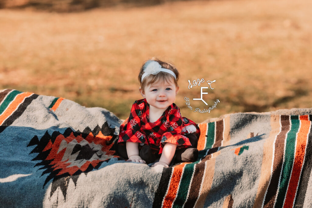 baby girl sitting on rock outside