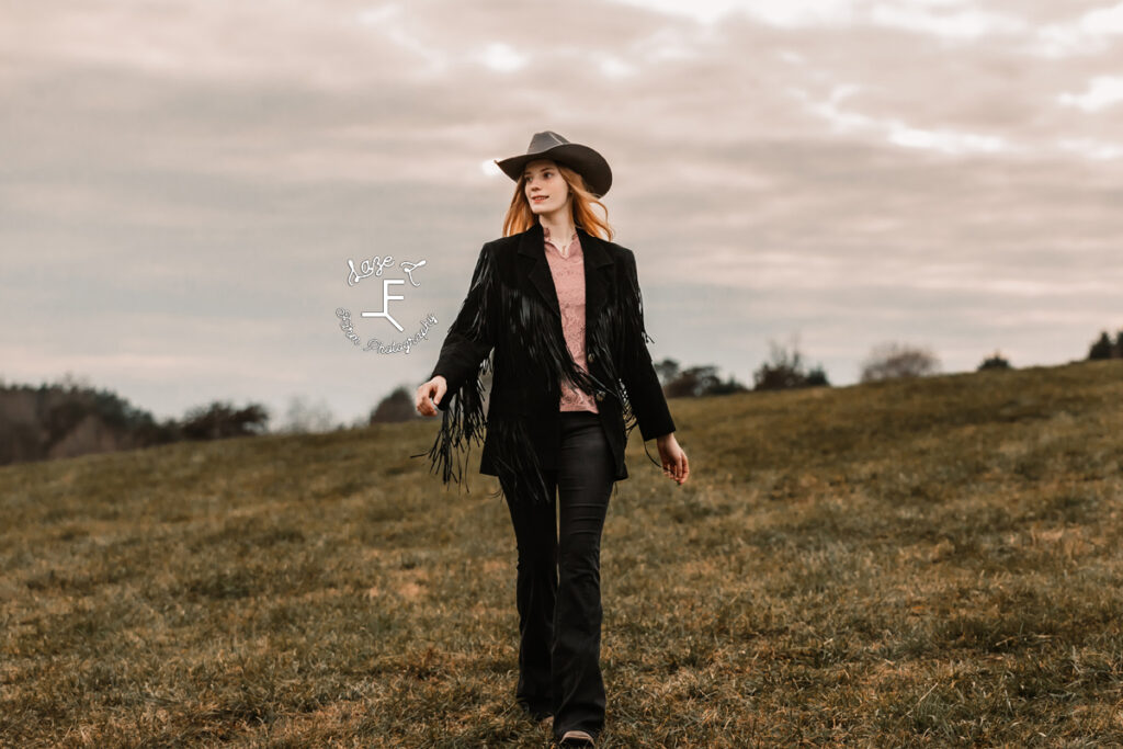 cowgirl in fringe jacket walking toward camera