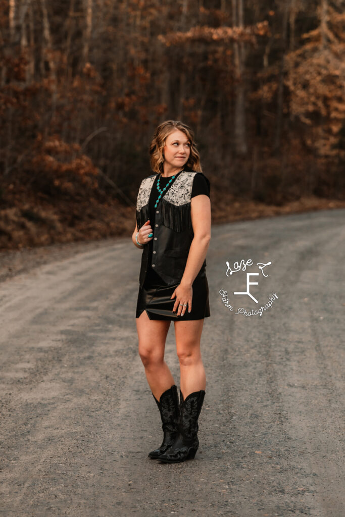 Kayla on dirt road in black skull vest