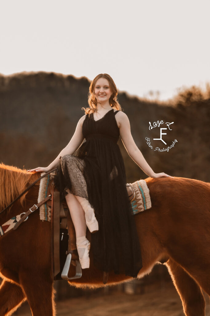 Amelia on horseback in ballet shoes in black dress