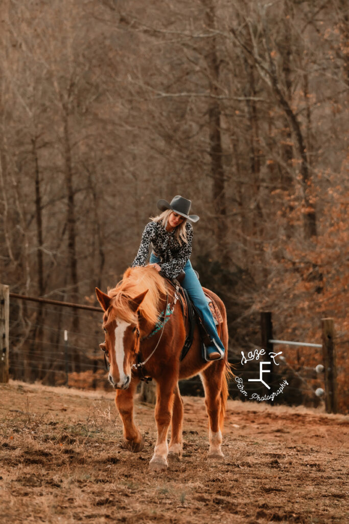 Model riding Gus patting his neck