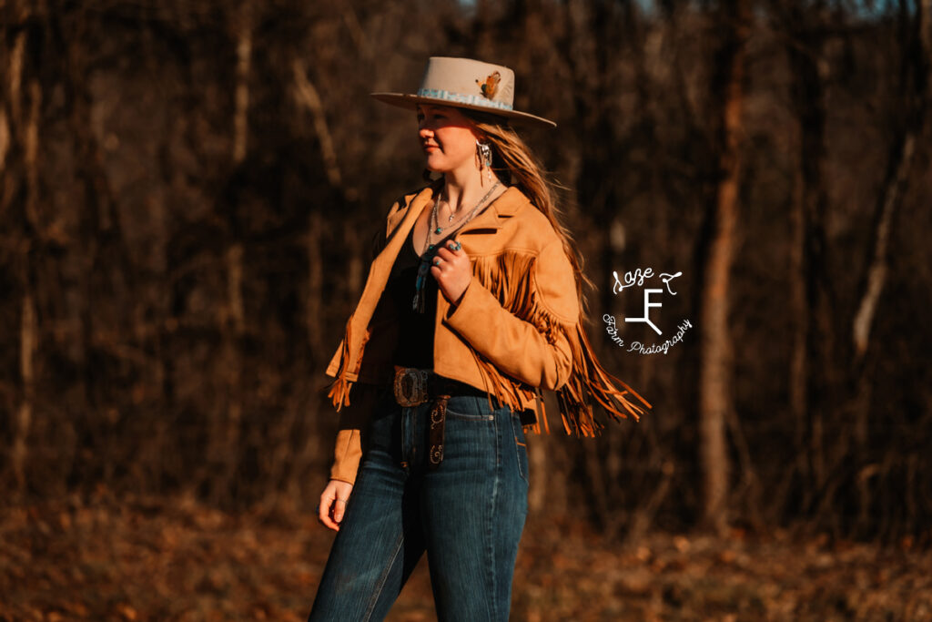 model in camel color fringe jacket looking left