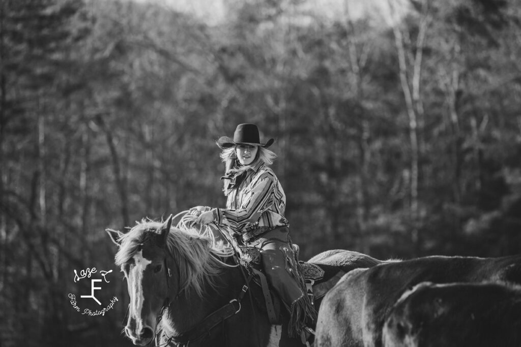 Maria riding Gus moving cows in black and white