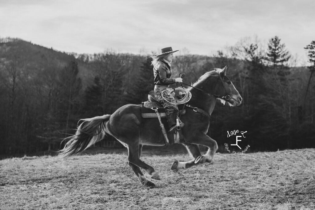 Maria loping Gus through field in black and white