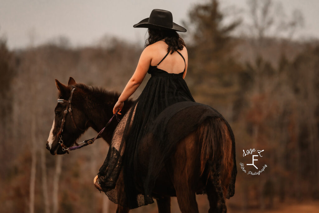 cowgirl in black dress riding away