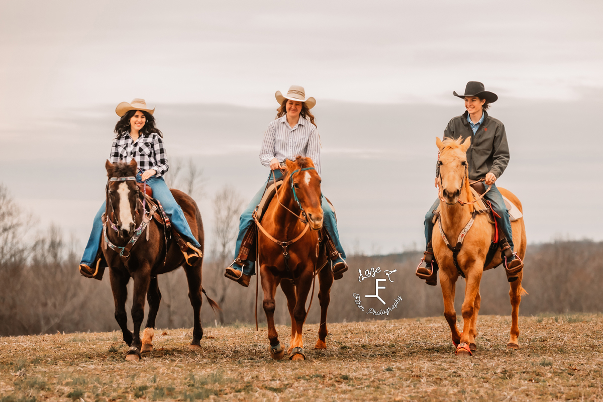 2 cowgirls and a cowboy riding towards camera