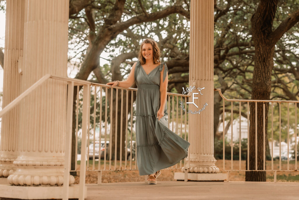 Kayla in green dress against railing