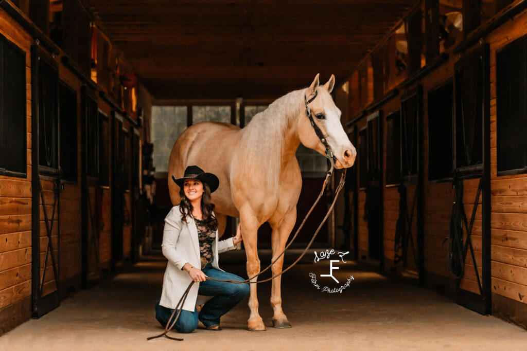 Amy kneeling beside Palomino horse