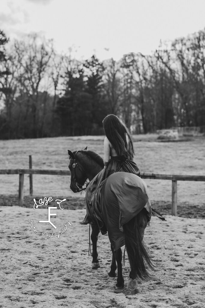 Danielle riding Chex away from camera in black and white