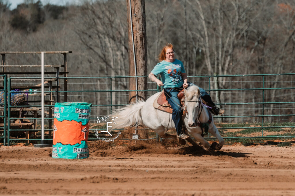 red head barrel racer on gray horse