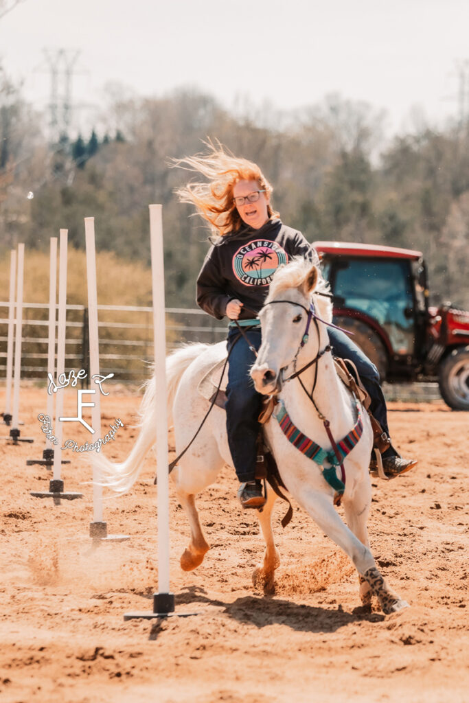 red head on gray horse doing poles